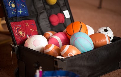 A suitcase containing different kinds of colourful balls and beanbags