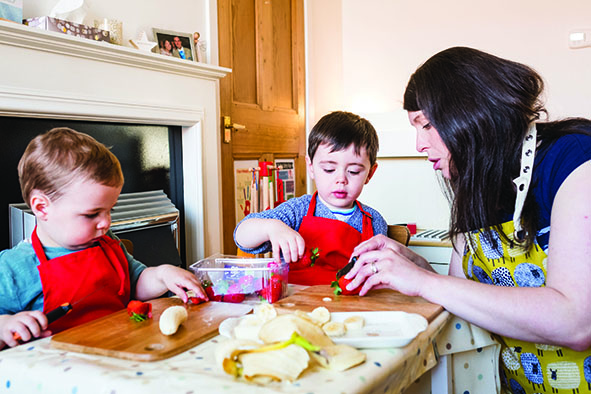 Children making food wearing red aprons