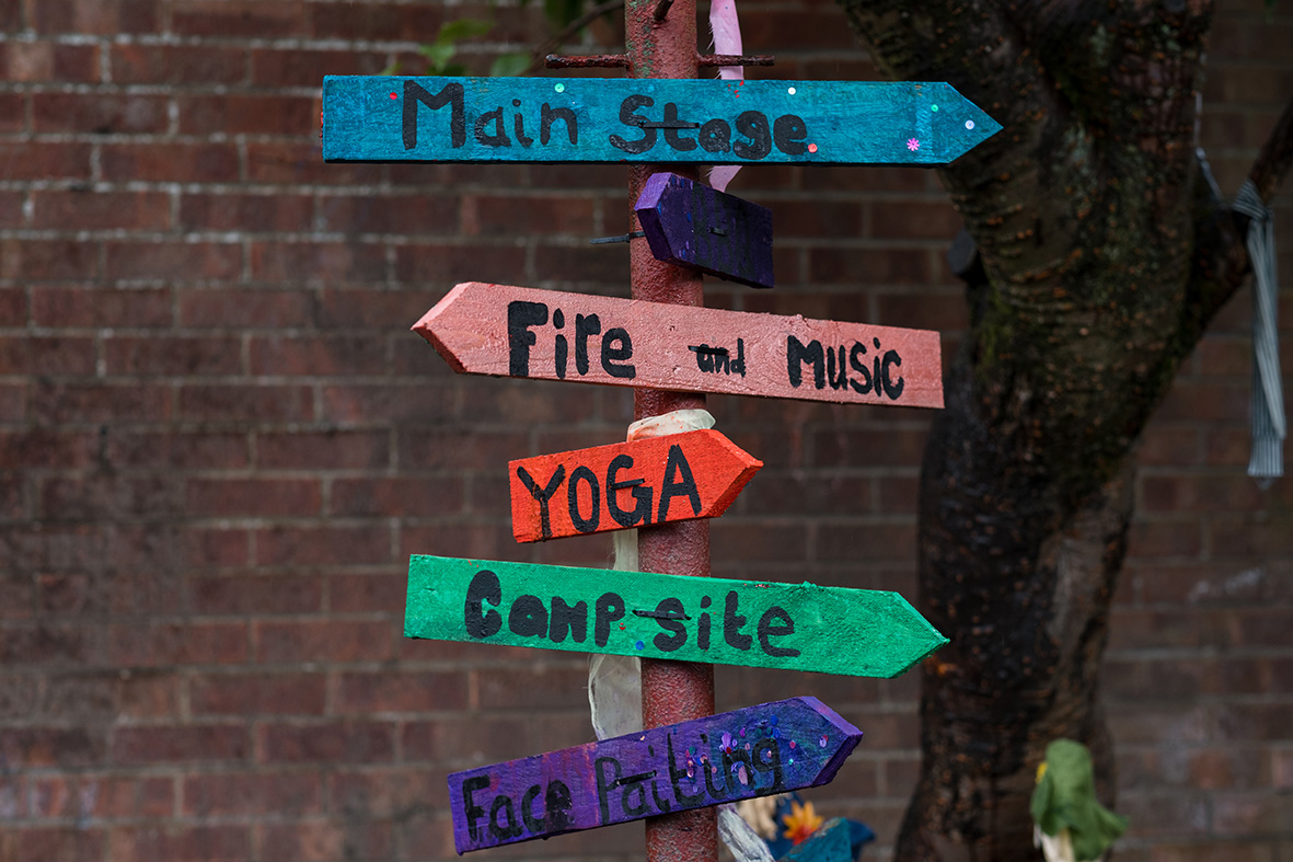 Coloured signposts providing directions to the main stage, fire and music, yoga, camp site and face painting