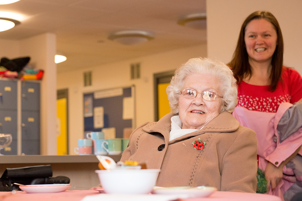 Older person smiling while sitting at table