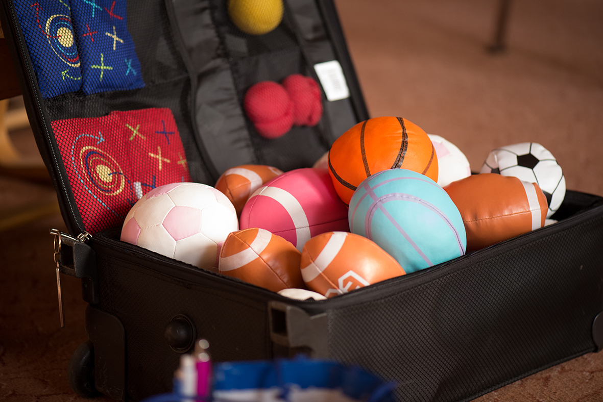A suitcase containing different kinds of colourful balls and beanbags
