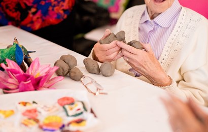 Older woman playing with clay