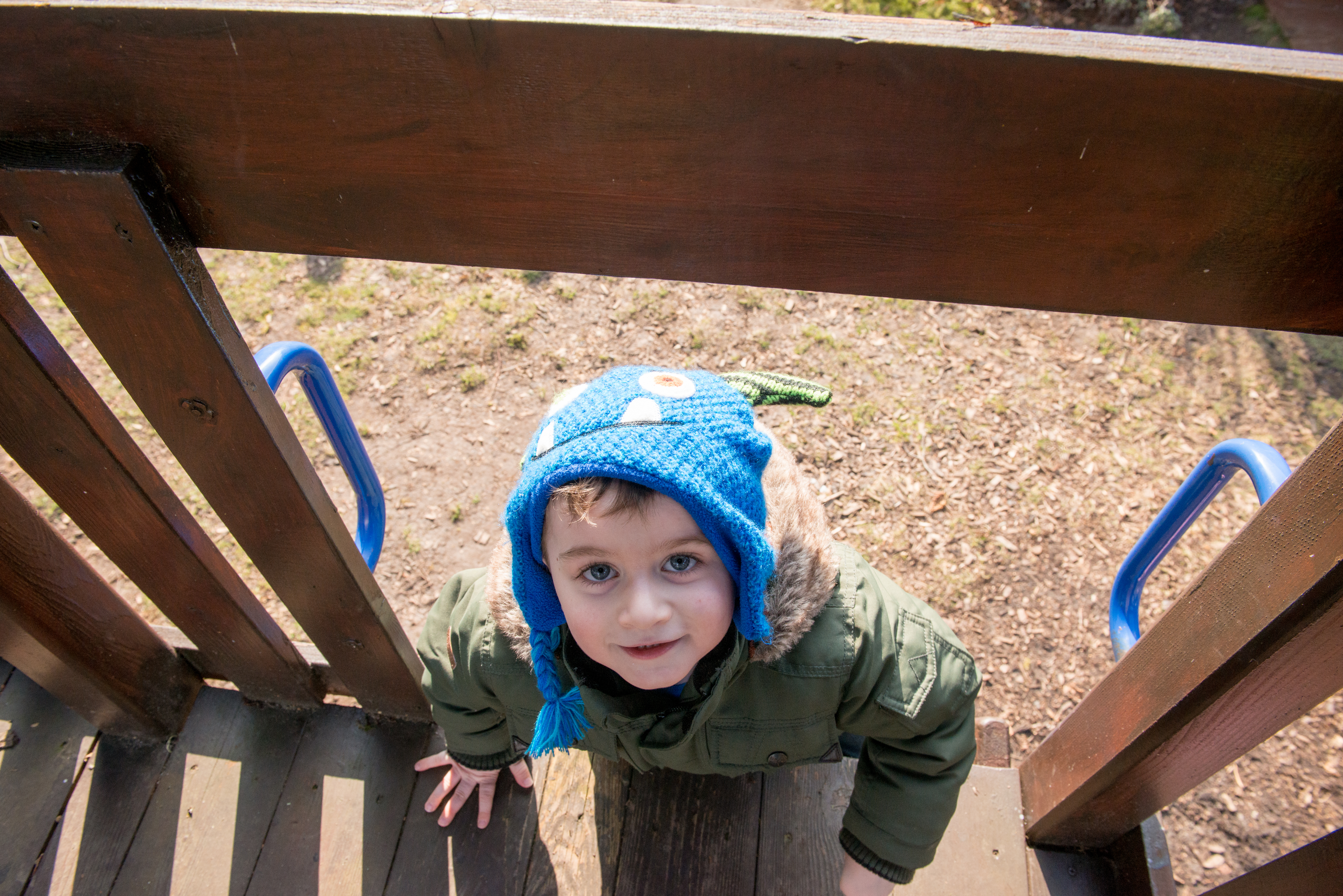 Young boy climbing on an outdoor frame