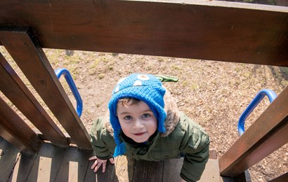 Young boy climbing on an outdoor frame