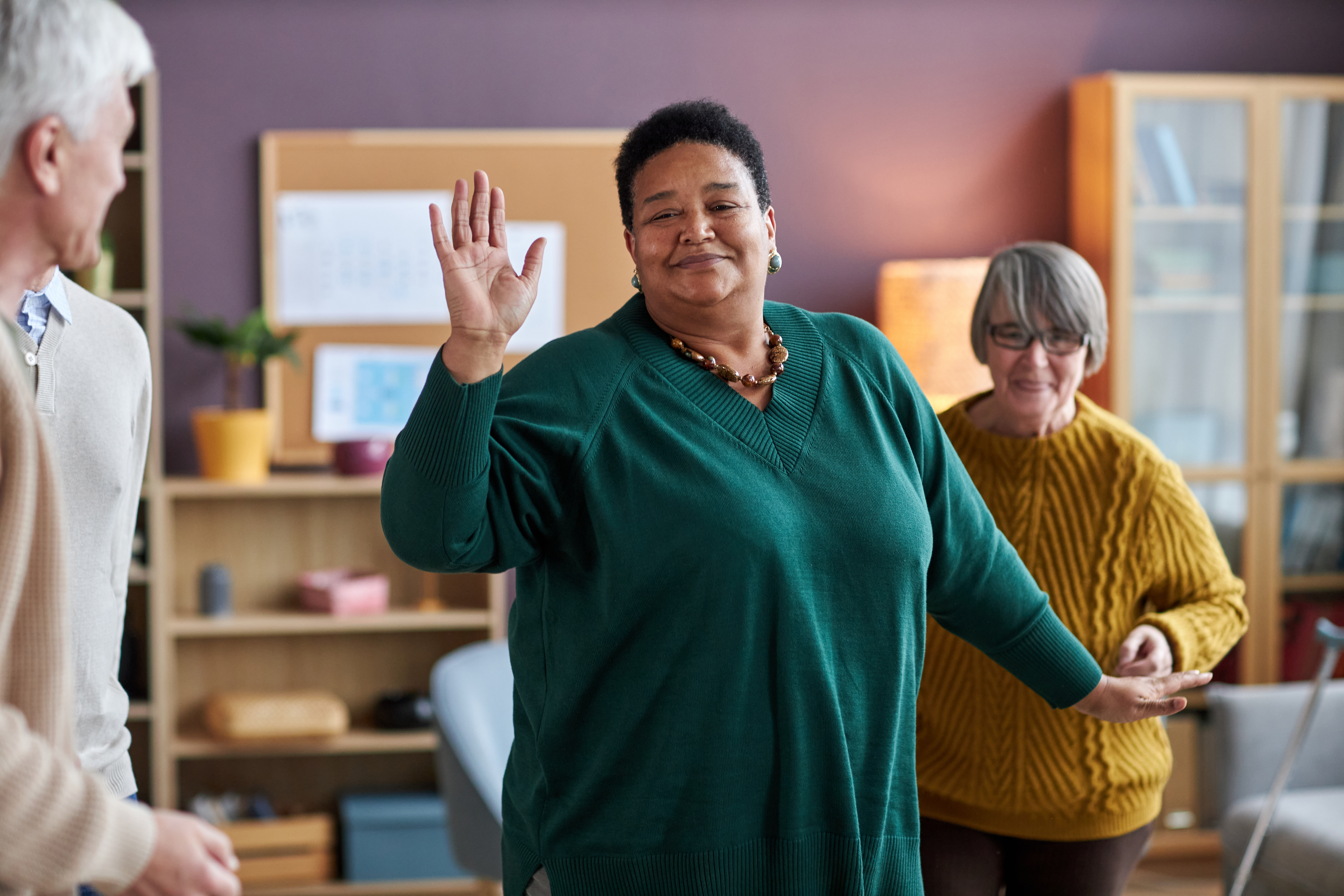 Cheerful black elderly woman dancing in a care home