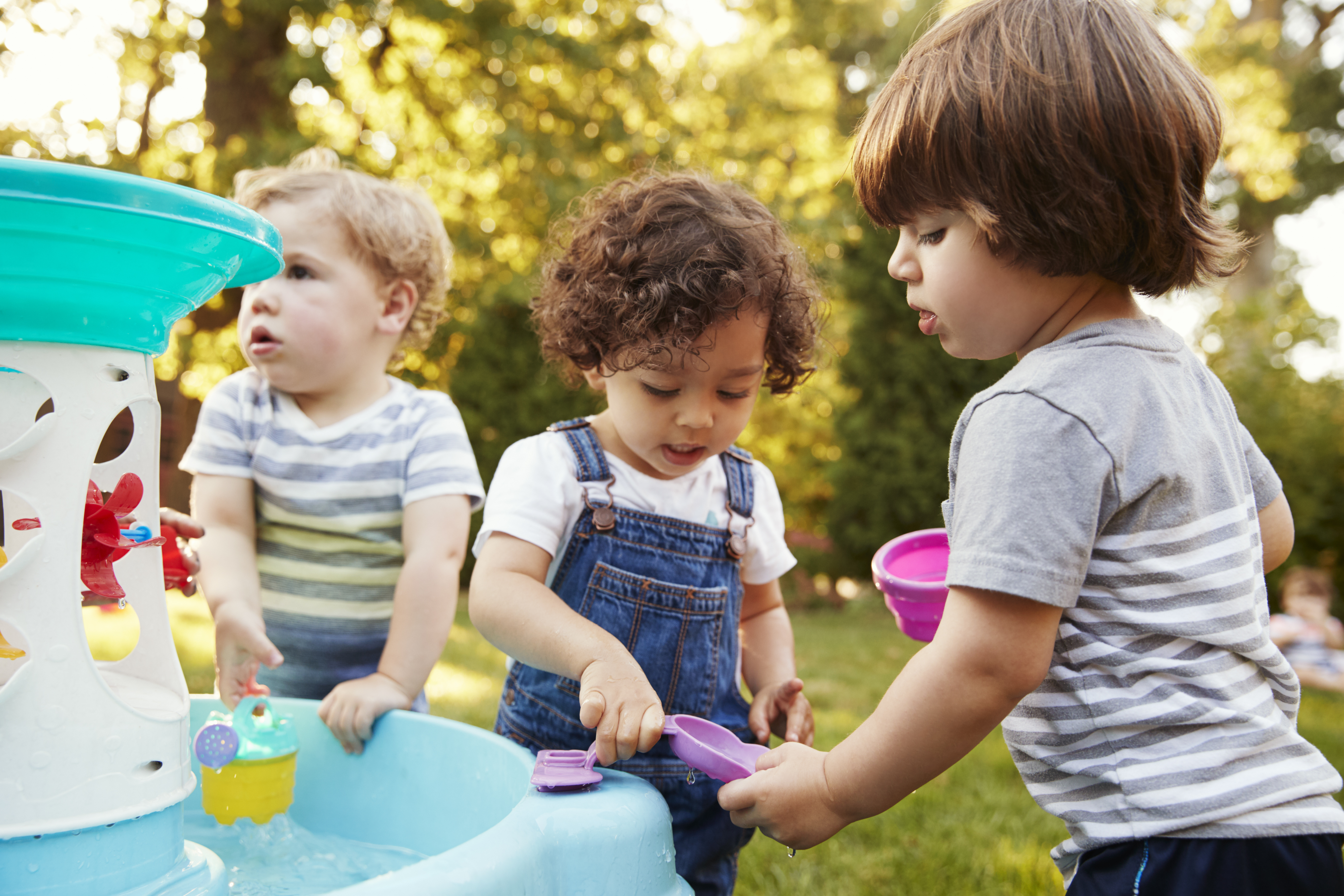 Children playing outside at a water table