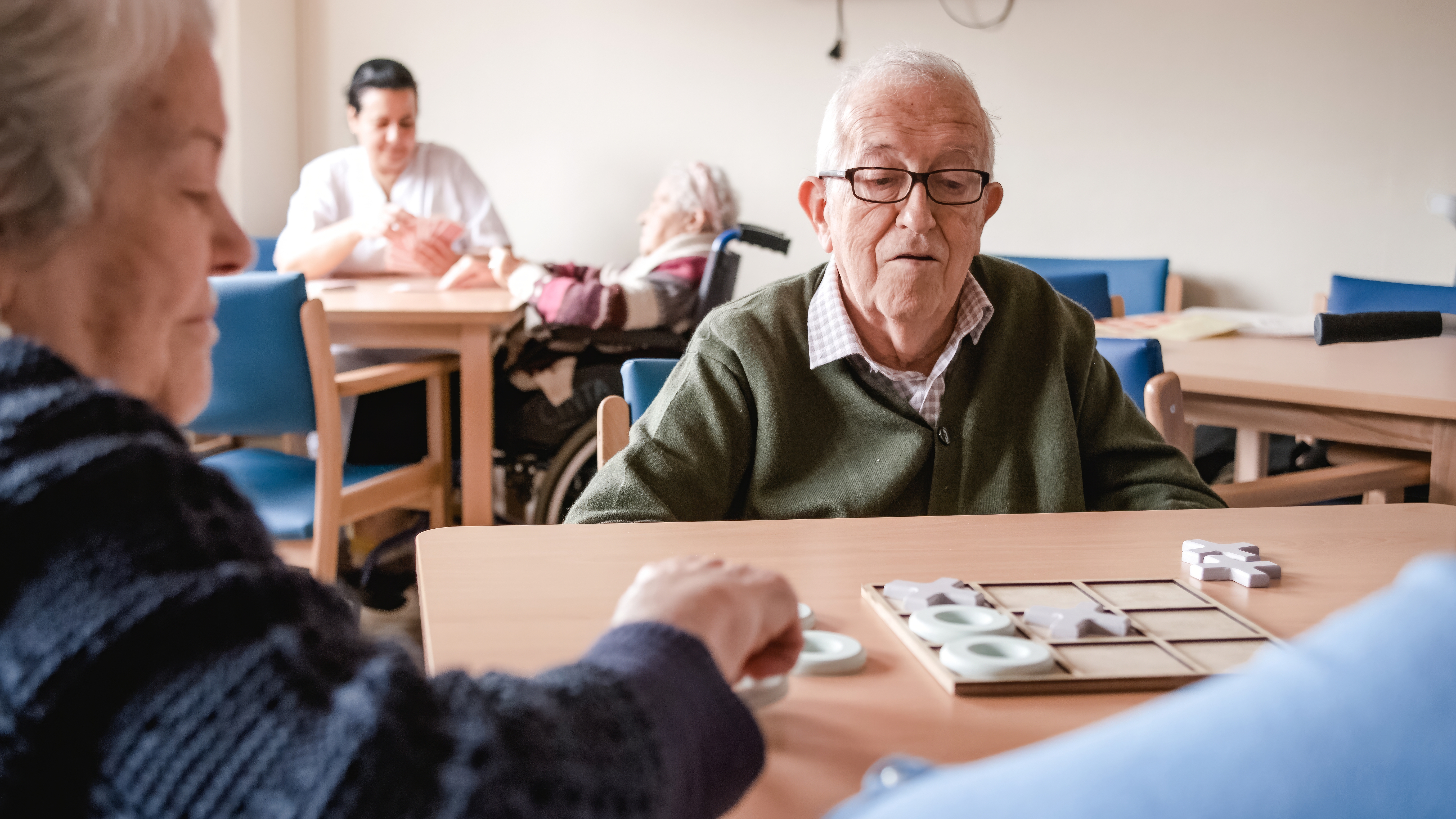senior-man-playing-tic-tac-toe-with-friends-in-nur-2024-06-05-00-33-01-utc