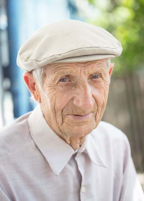 Portrait of an elderly man wearing a bonnet